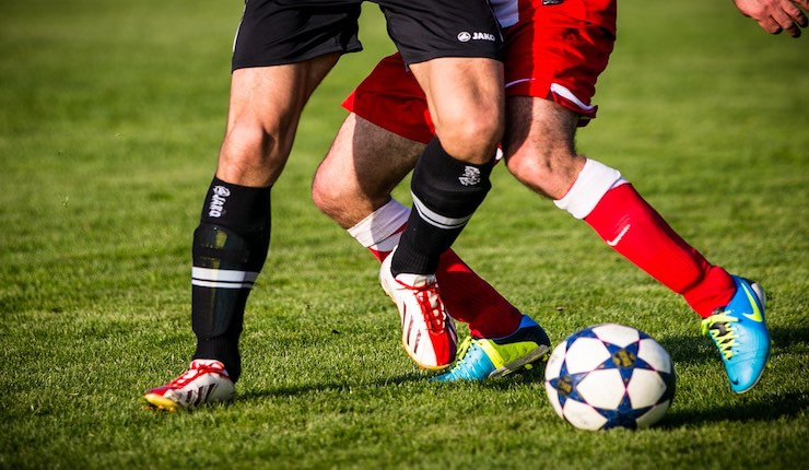 Two football players battling for the ball