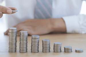 hand placing coin on stack of coins