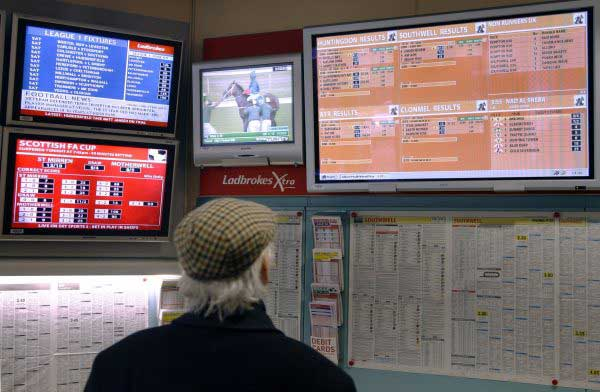 A man checks the results of an event at a betting shop.