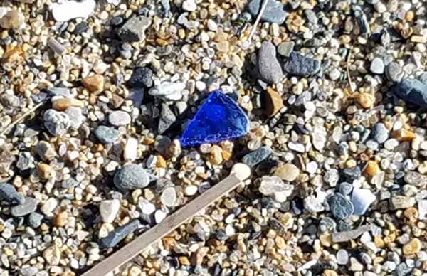 Blue sea glass in the sand at Kinney Shores Beach, Maine.