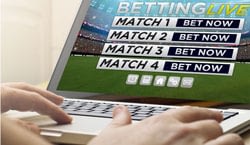 Man using a laptop to place football bets.