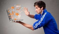 Man wearing a football shirt and holding a laptop which has statistics coming out of it.
