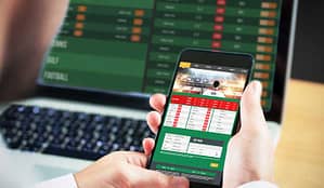 A man places an online bet on his mobile phone