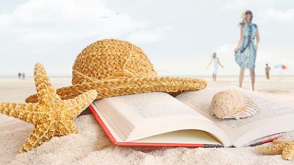 Book, starfish, shell and hat on the beach