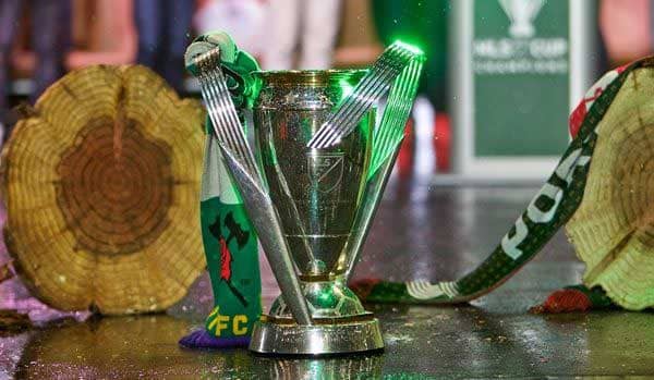 The MLS Cup trophy stands next to two logs, signifying Portland Timbers' 2015 victory.