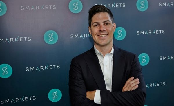 Smarkets.com founder Jaston Trost stands in front of the company logo.