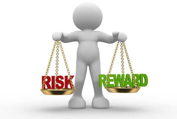 Scales balancing "Risk" and "Reward".