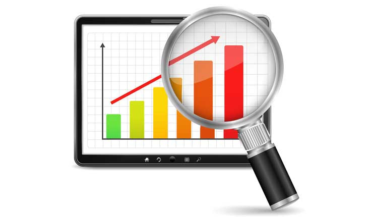 A magnifying glass looking at a bar chart