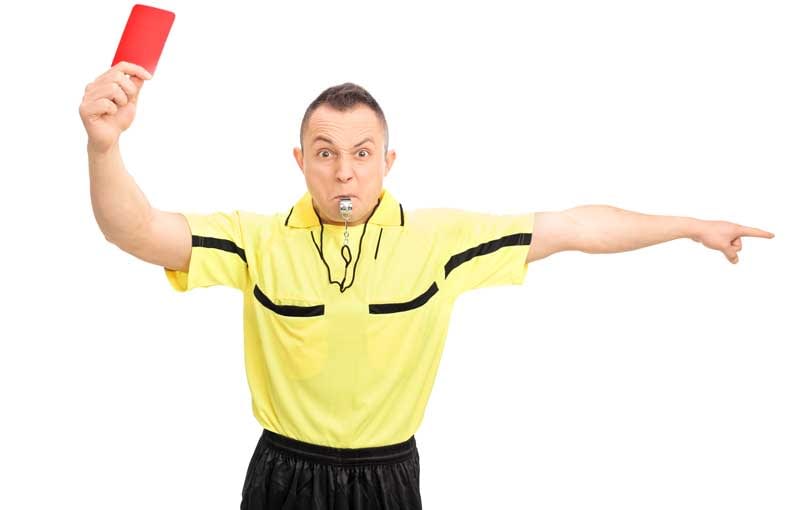 A football referee holding up a red card
